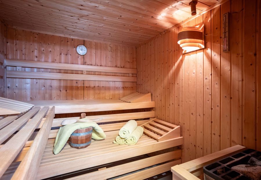 Holzsauna mit mehreren Sitz- und Liegebänken sowie Saunaofen